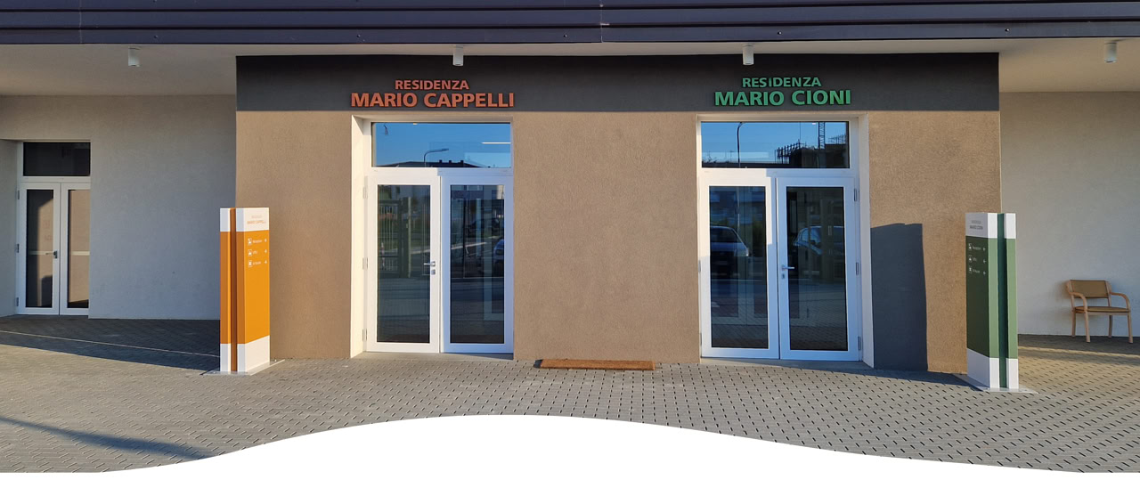 Sala comune della RSA con poltrone, tavoli e accesso al giardino