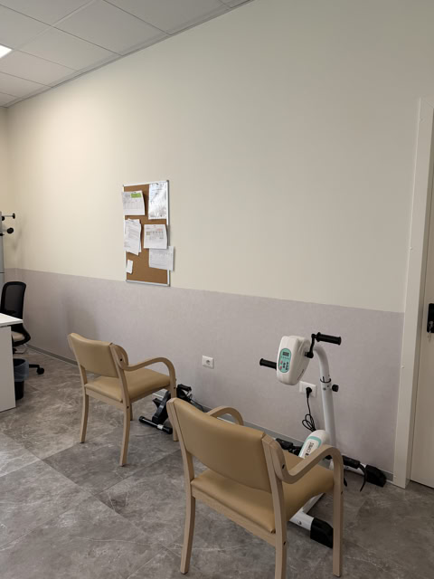 Locale con cyclette manuale e sedute per esercizi di mobilizzazione